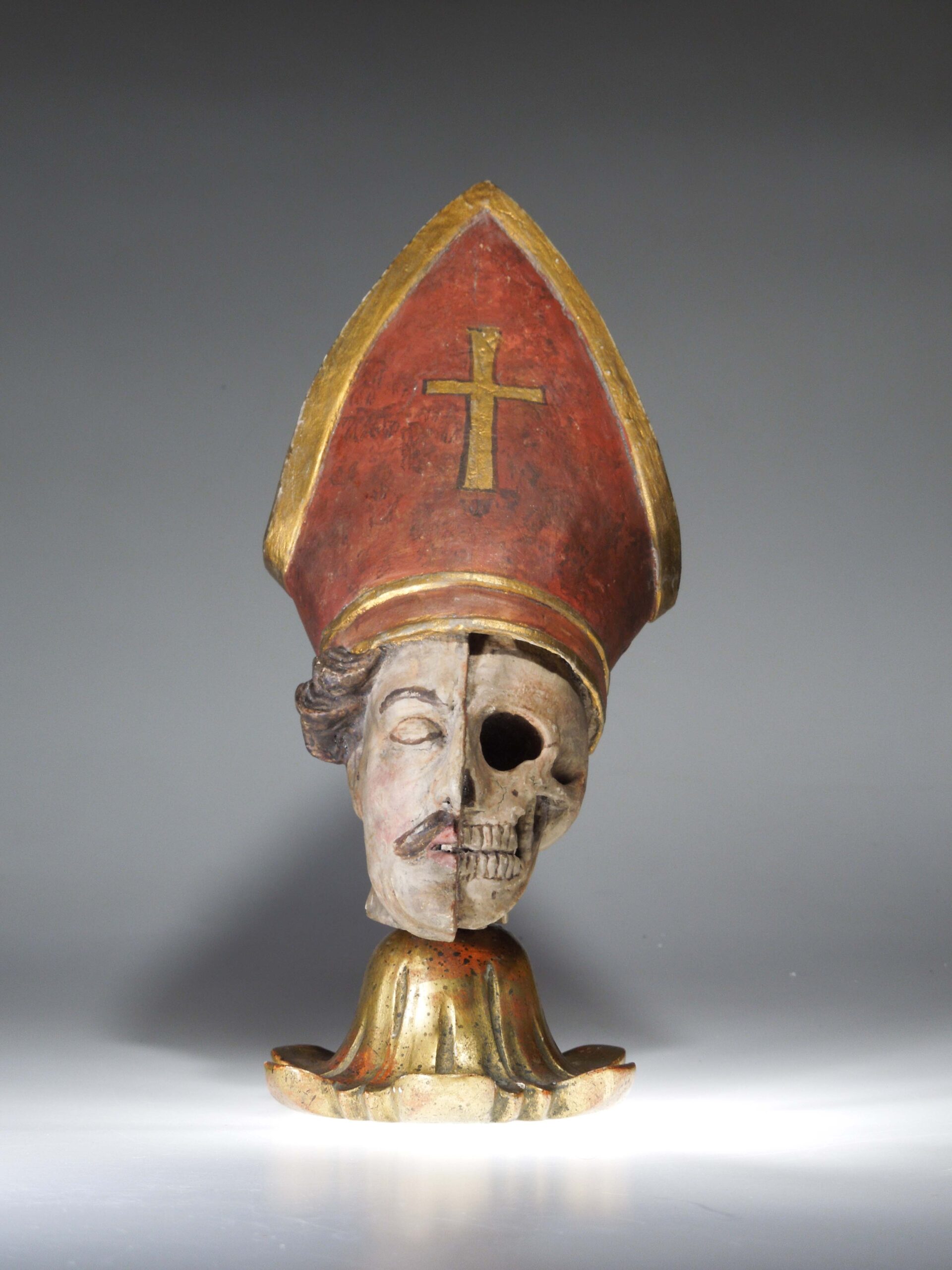 Dřevěná socha biskupovi hlavy s mitrou